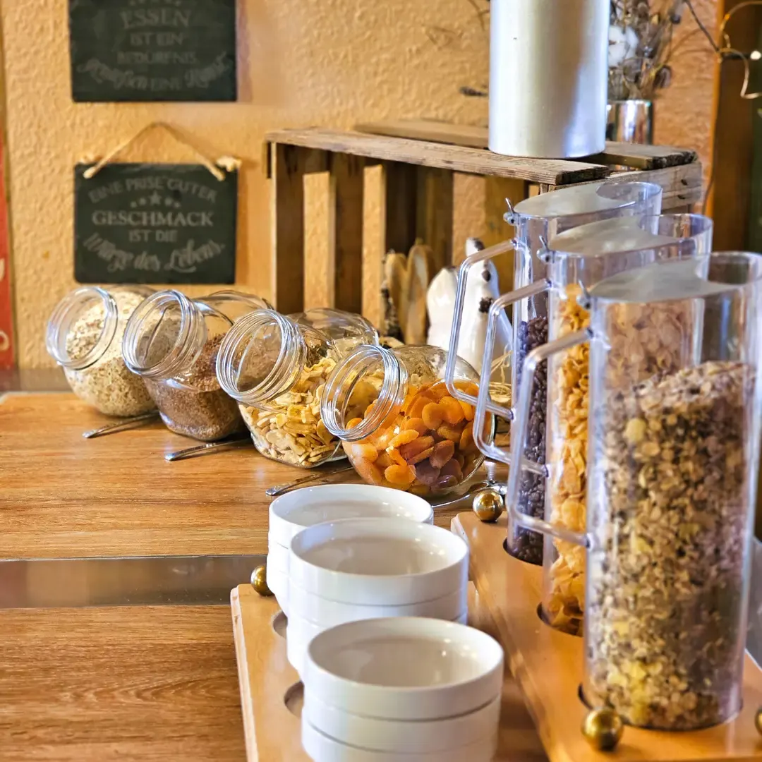 Müsli-Bar mit Gläsern voller Flocken, Nüsse und Früchte am Frühstücksbuffet