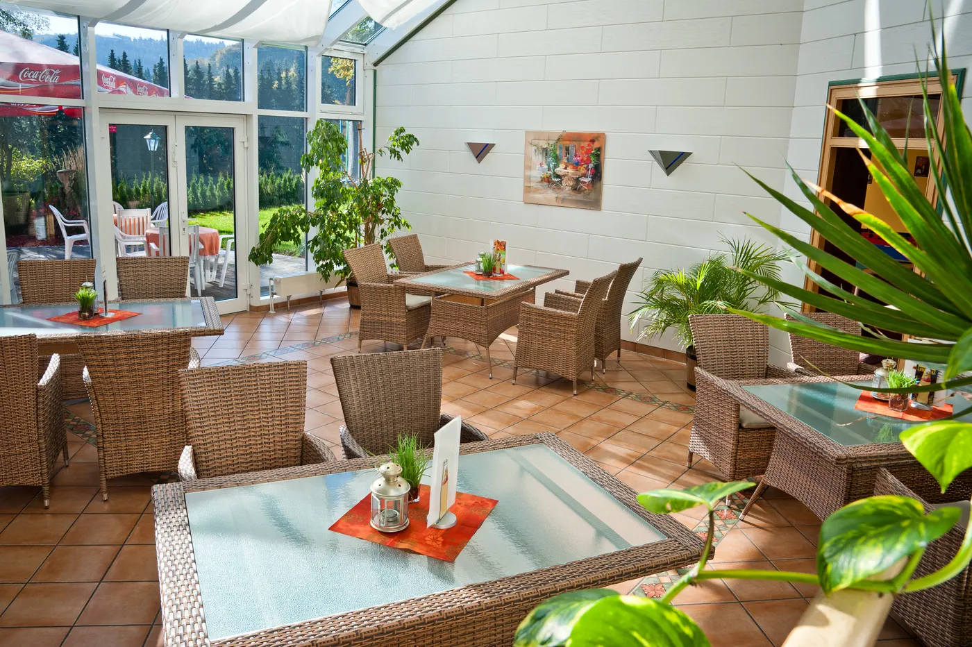 Heller Wintergarten des Henkenhofs mit Tischen und Pflanzen