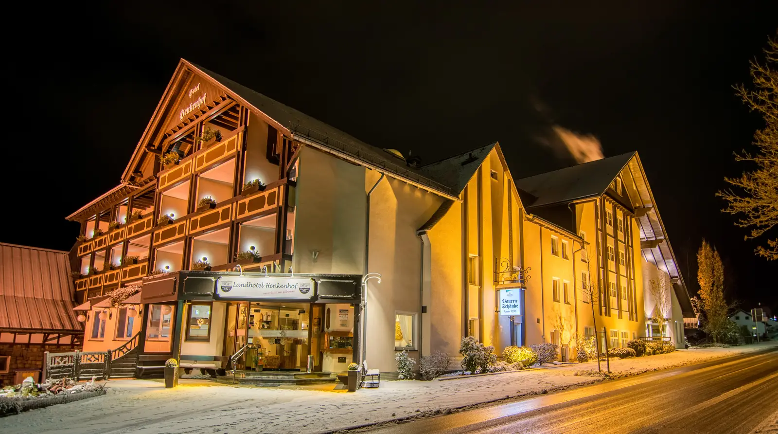 Das beleuchtete Landhotel Henkenhof an einem Winterabend mit Schnee