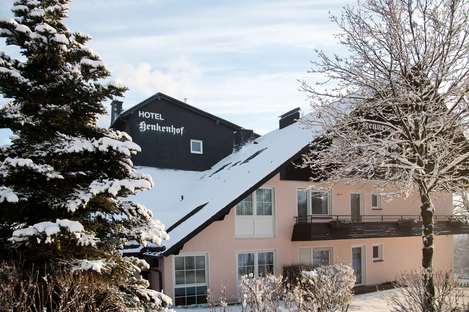 Das Landhotel Henkenhof mit verschneitem Dach und Schnee auf den Bäumen